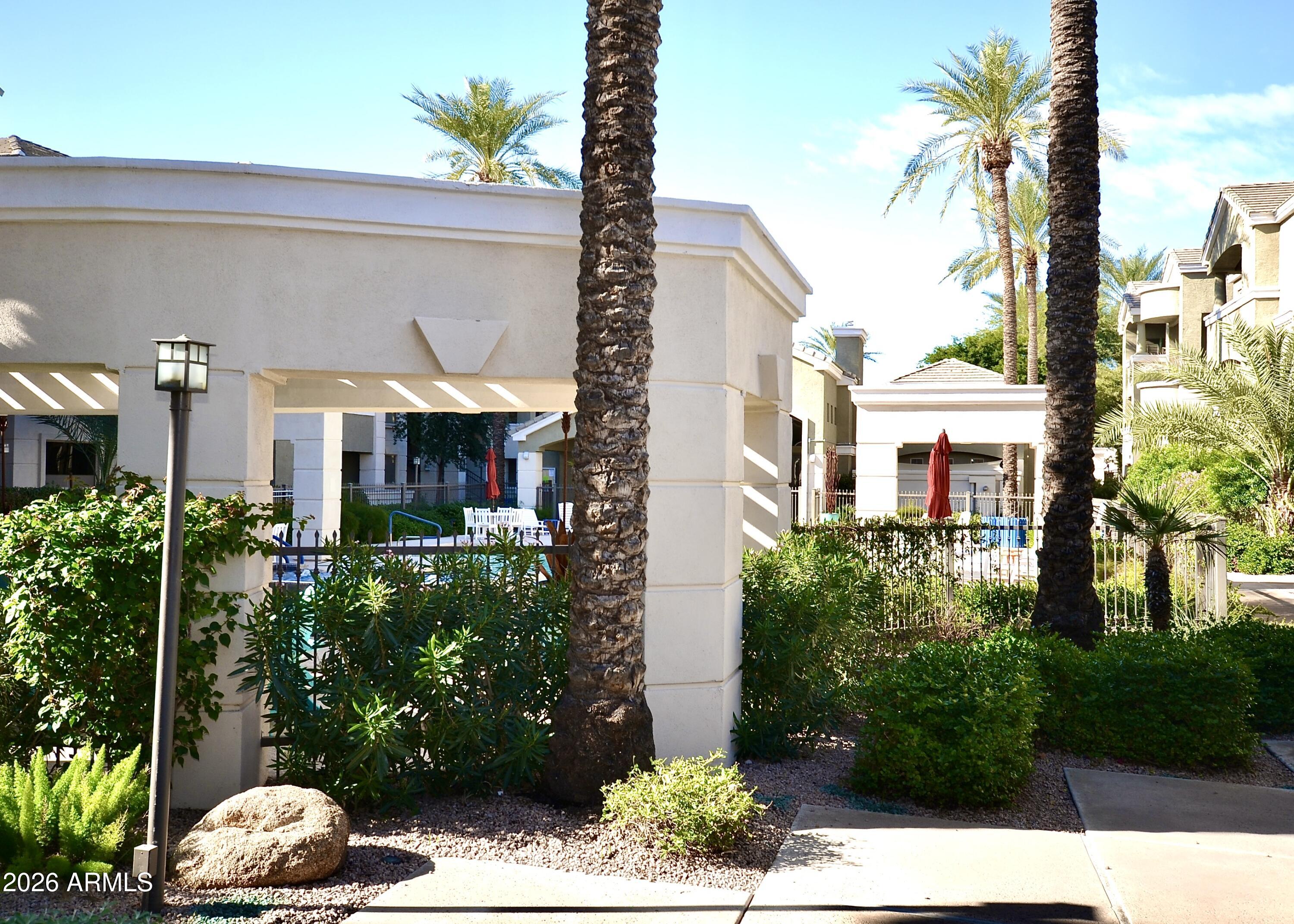 5303 North 7th Street, Unit 117 Phoenix, AZ 85014 - Photo 21 of 31 a front view of a house with a yard and potted plants