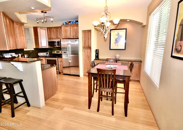 a kitchen with stainless steel appliances wooden floor dining table and chairs