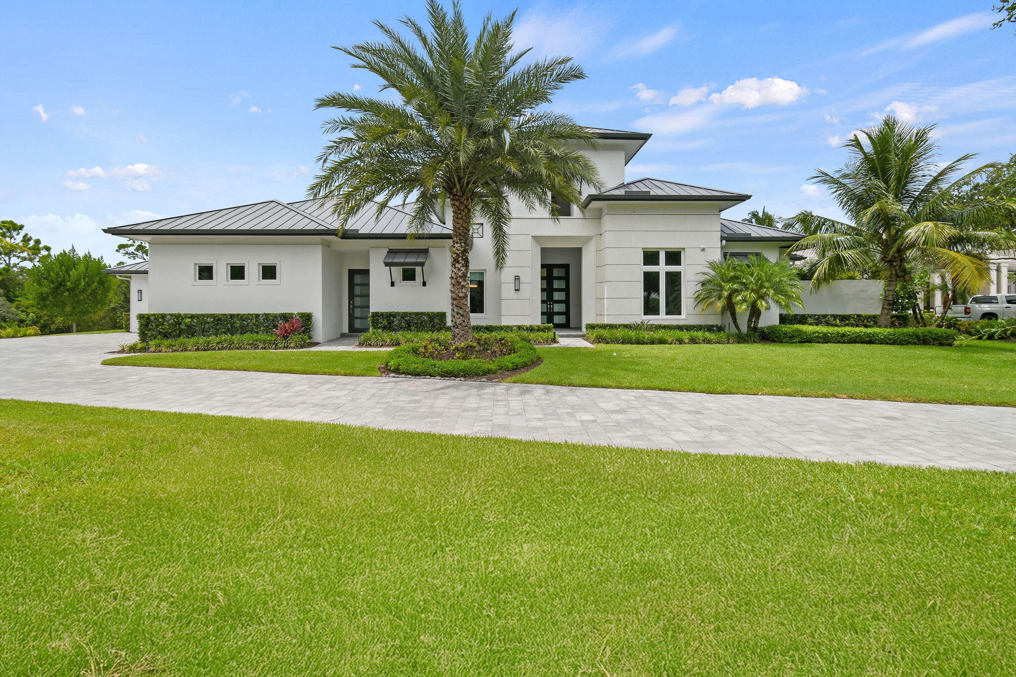 6219 Southeast Moss Ridge Pointe Hobe Sound, FL 33455 - Photo 5 of 108 a front view of a house with a yard and garage