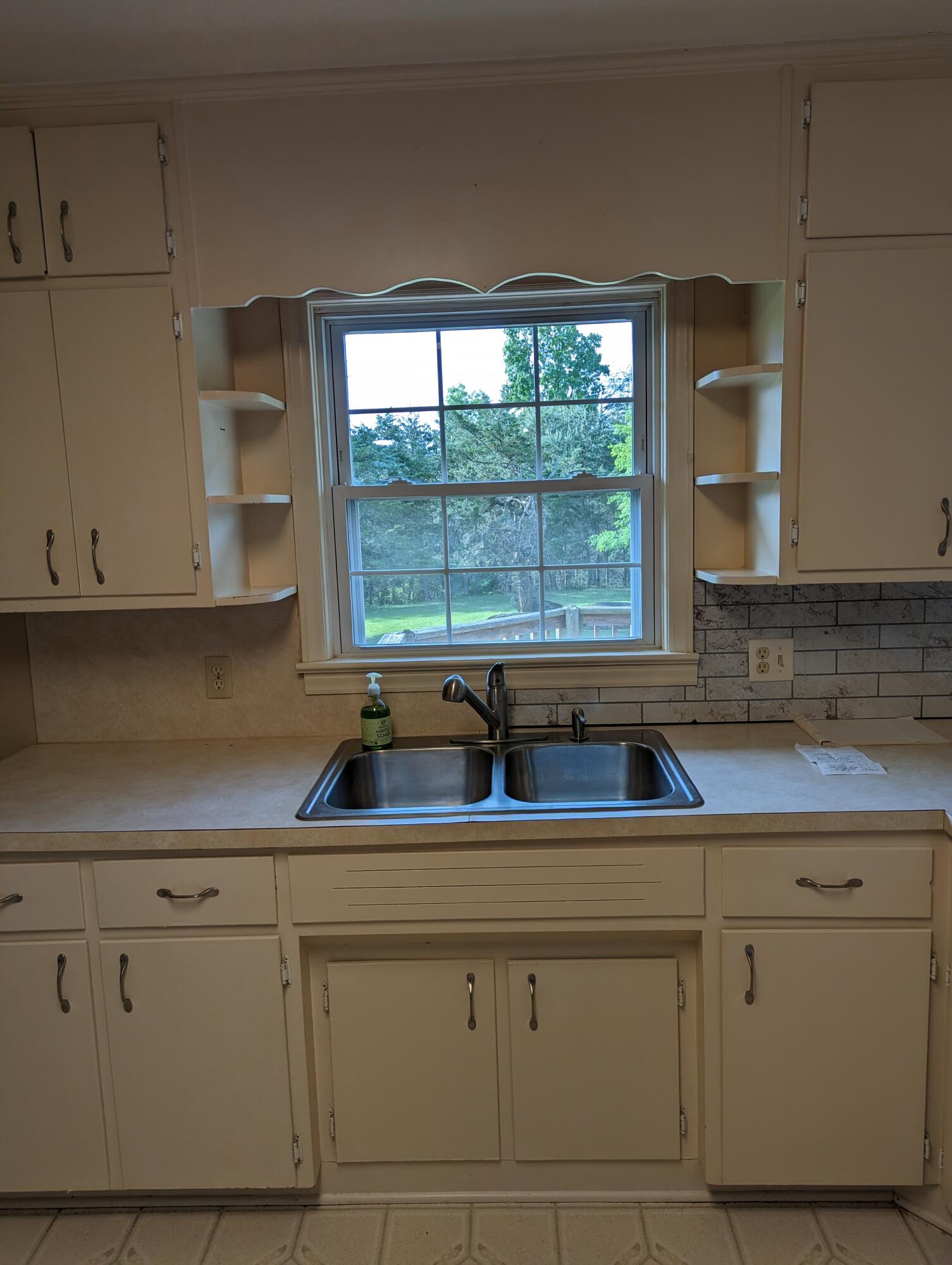 7214 6 Mile Post Road Rocky Mount, VA 24151 - Photo 6 of 45 a kitchen with white cabinets and a large window