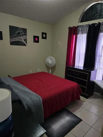 a bedroom with a bed and a painting on the wall