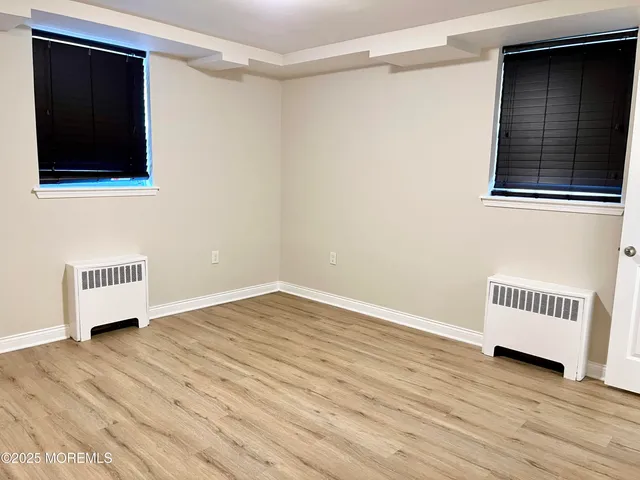 a view of a room with wooden floor and white walls