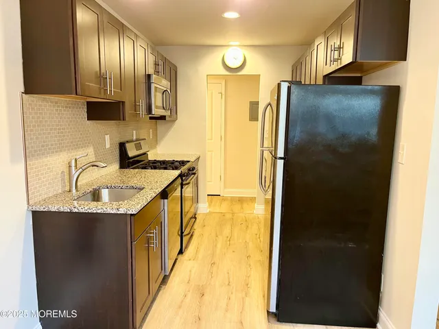 a kitchen with stainless steel appliances granite countertop a granite counter tops and a refrigerator