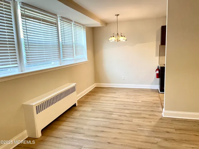 a view of a room with wooden floor and chandelier