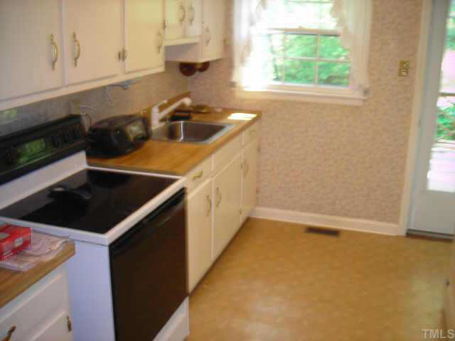 604 Chatham Lane Raleigh, NC 27610 - Photo 3 of 6 a kitchen with a sink a stove and cabinets