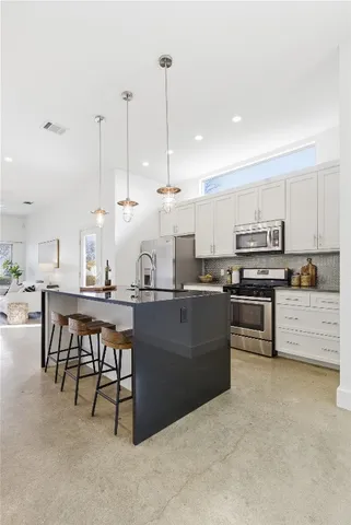 a kitchen with stainless steel appliances kitchen island granite countertop a table and chairs
