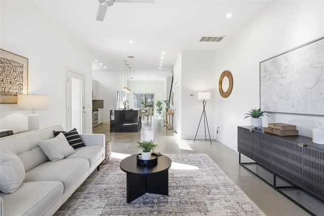 a kitchen with stainless steel appliances granite countertop a stove a refrigerator a kitchen island a dining table and chairs