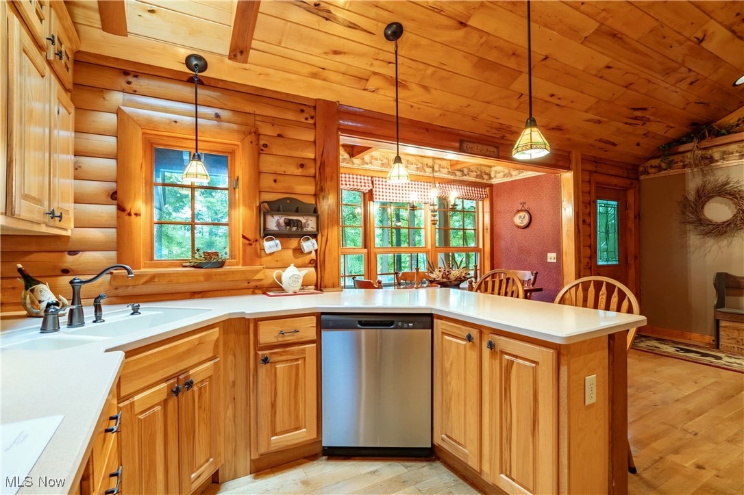 49144 Hickman Road Calcutta, OH 43920 - Photo 6 of 23 Kitchen featuring kitchen peninsula, log walls, and stainless steel dishwasher