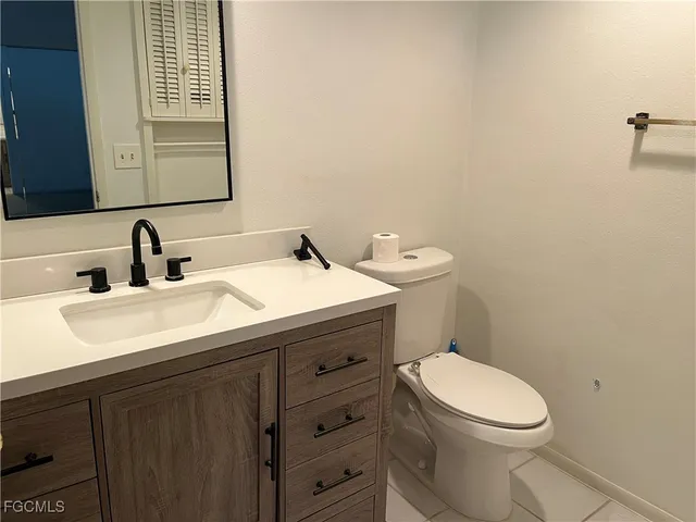 a bathroom with a toilet a sink a vanity and mirror