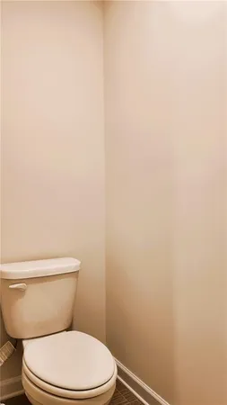 a white toilet sitting next to a white wall