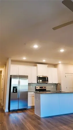a kitchen with stainless steel appliances a refrigerator and a stove top oven