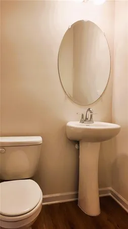 a bathroom with a sink a toilet and mirror