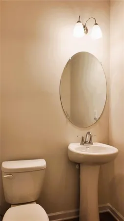 a bathroom with a sink mirror and toilet