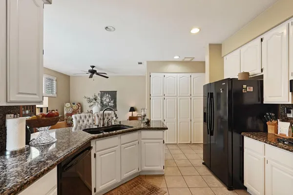 a kitchen with granite countertop a refrigerator and a sink