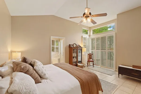 a bedroom with a bed a window and a chandelier