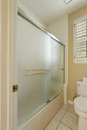 a bathroom with a granite countertop shower and a toilet