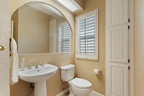 a bathroom with a sink a toilet and a mirror