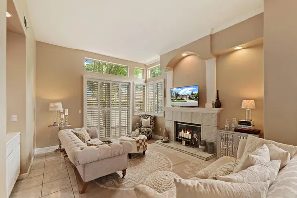 a living room with furniture a fireplace and a large mirror with wooden floor