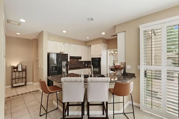 a kitchen with stainless steel appliances refrigerator dining table and chairs
