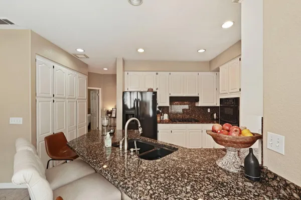 a kitchen with sink refrigerator and cabinets