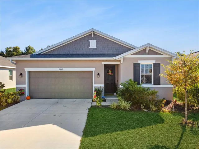 a front view of a house with a garden and plants