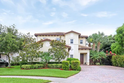 a front view of a house with a garden and trees
