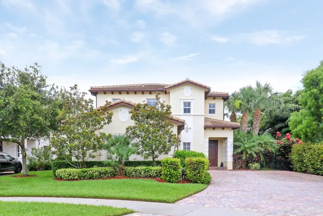 a front view of a house with a garden and trees