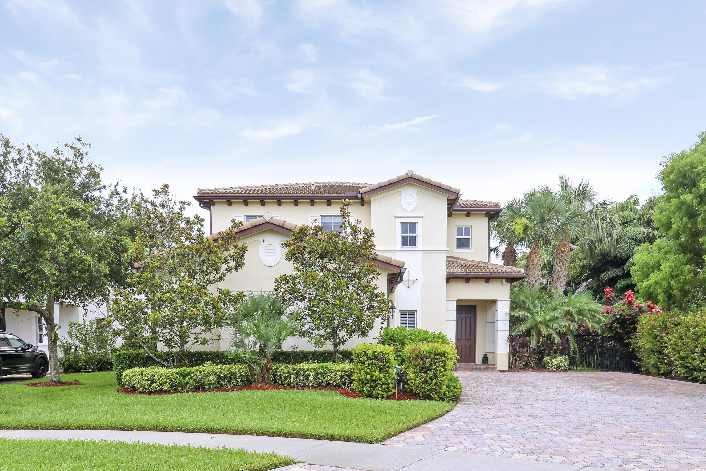 a front view of a house with a garden and trees