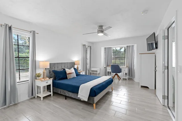 a bedroom with a bed wooden floor and window
