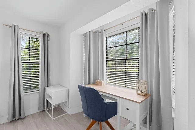 a view of a workspace with a window and chair