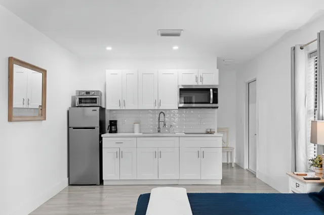 a kitchen with a sink a microwave a refrigerator and cabinets