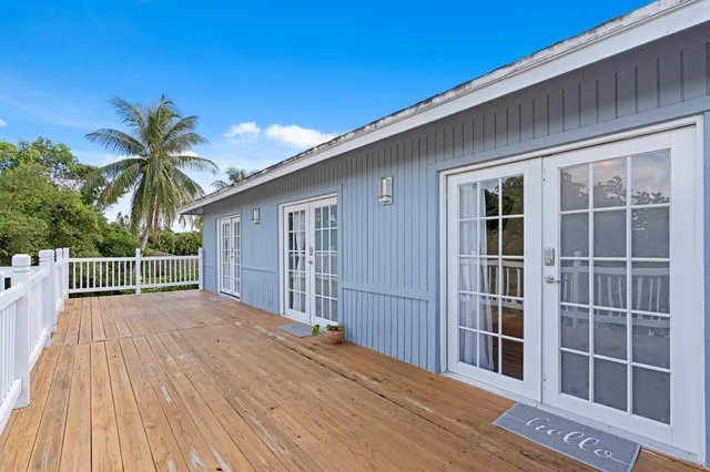 a view of backyard with large trees and wooden fence