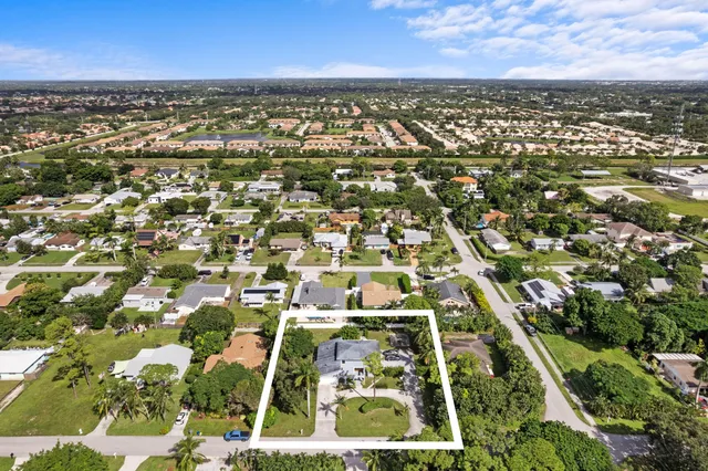 an aerial view of residential houses with outdoor space and trees