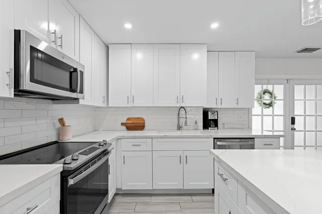 a kitchen with white cabinets stainless steel appliances and sink