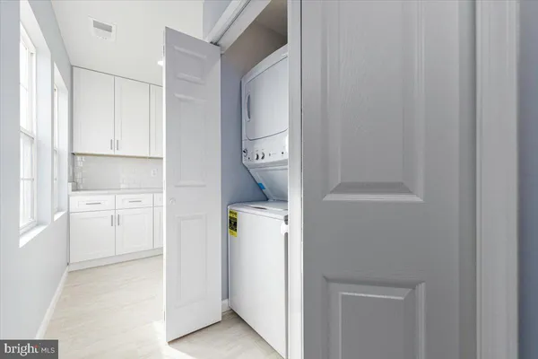 a kitchen with white cabinets and refrigerator