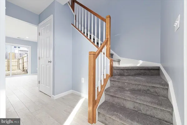 a view of staircase with wooden floor and a rug