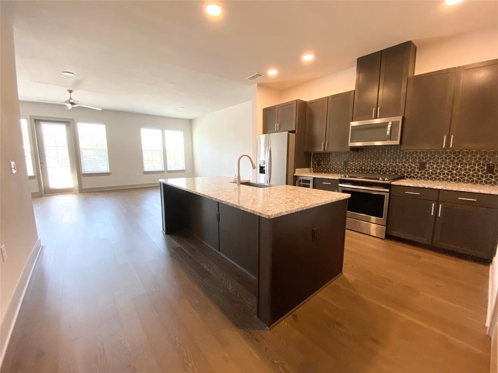a large kitchen with stainless steel appliances granite countertop a sink and a stove