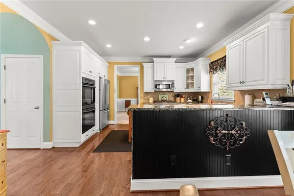 a kitchen with granite countertop a refrigerator and a stove top oven