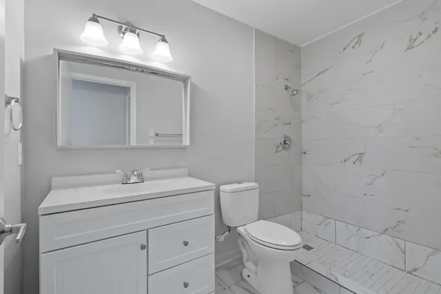 a bathroom with a sink a toilet and shower