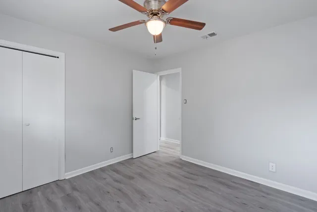 a view of an empty room and chandelier fan