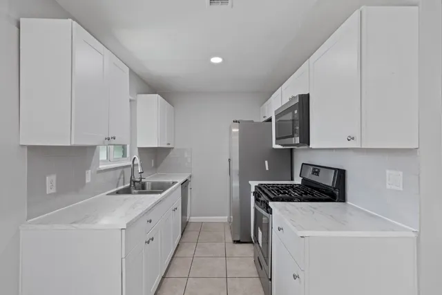 a kitchen with stainless steel appliances a sink stove and cabinets