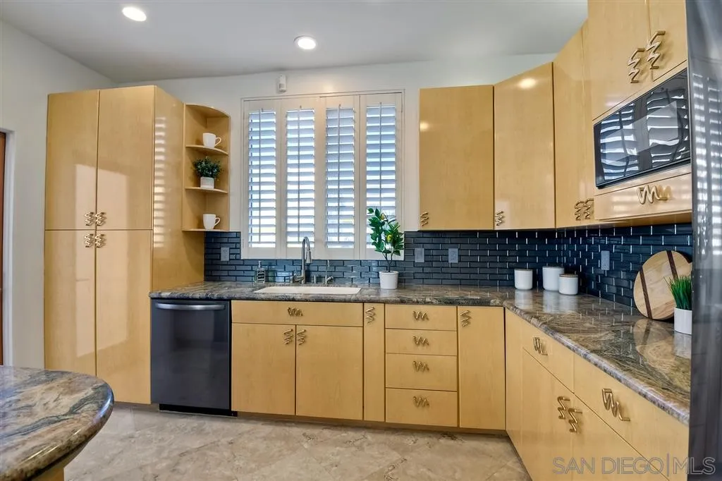 2136 Glasgow Avenue Cardiff, CA 92007 - Photo 11 of 25 a kitchen with stainless steel appliances granite countertop a sink and a refrigerator
