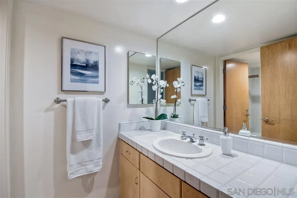 2136 Glasgow Avenue Cardiff, CA 92007 - Photo 14 of 25 a bathroom with a granite countertop sink and a mirror