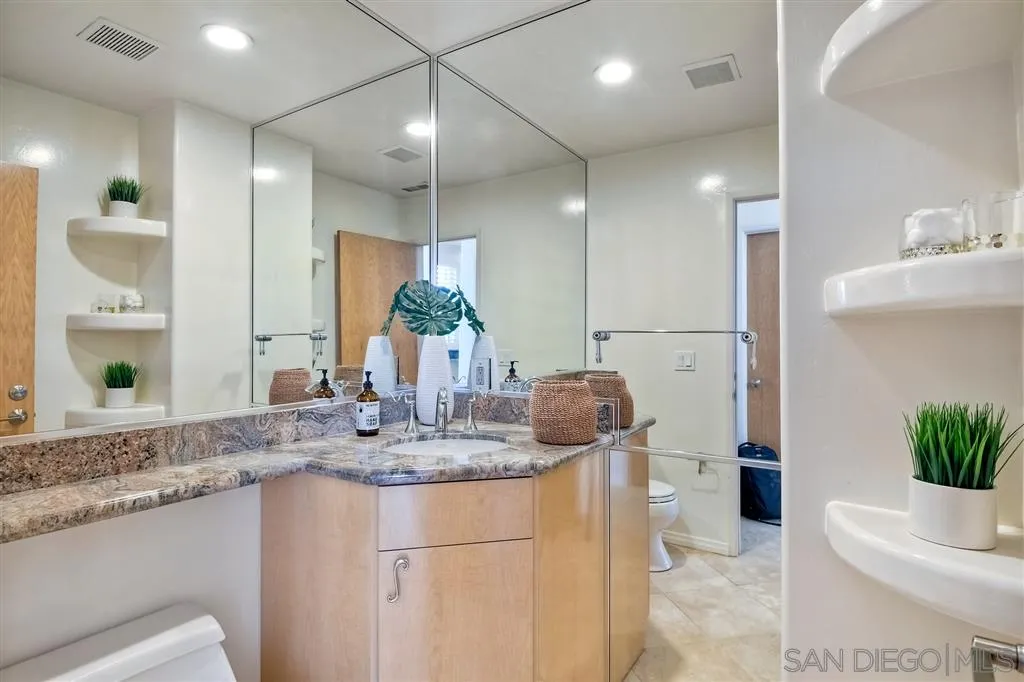 2136 Glasgow Avenue Cardiff, CA 92007 - Photo 18 of 25 a bathroom with a granite countertop sink a toilet and a mirror