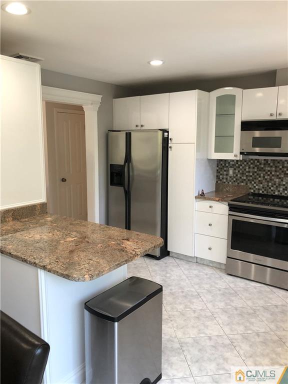 144 Kimberly Road Colonia, NJ 07067 - Photo 6 of 27 a kitchen with stainless steel appliances granite countertop a stove a refrigerator and a sink