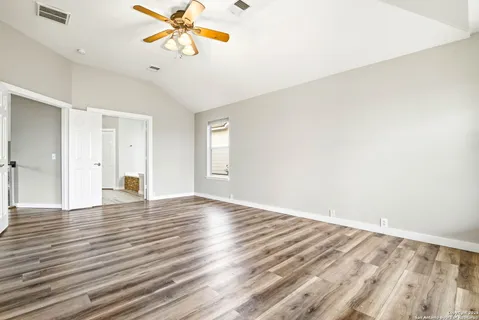 a view of an empty room with window and wooden floor
