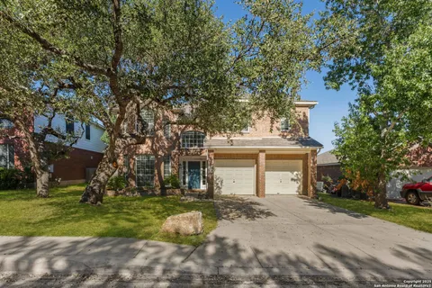 a front view of a house with a yard and tree s