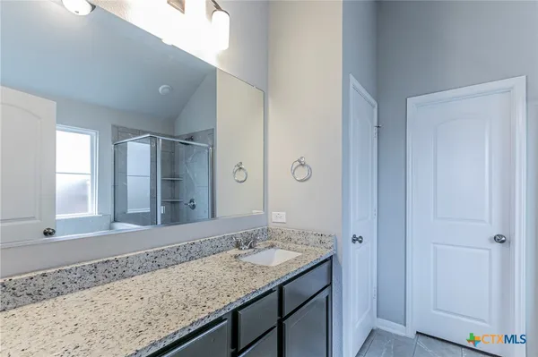 a bathroom with a granite countertop sink and a mirror
