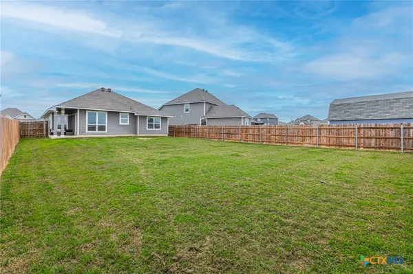a view of a house with a yard and sitting area