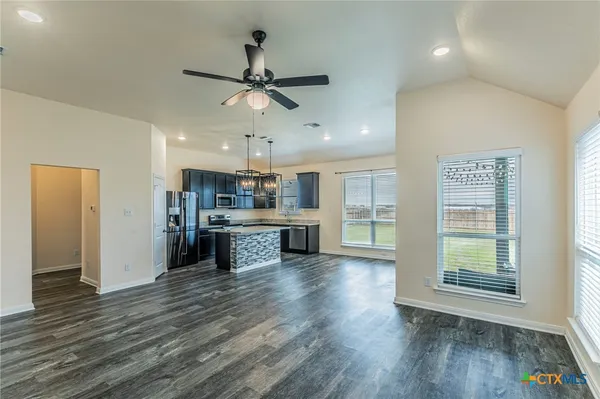 a large kitchen with a wooden floor and stainless steel appliances